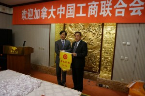 中国侨联主席林军向加中工商联代表团团长滕达赠送锦旗